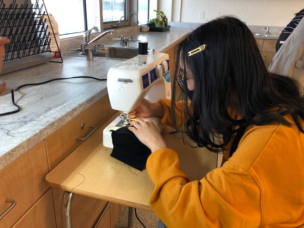 A Holy Trinity Catholic High School student sewing a mask