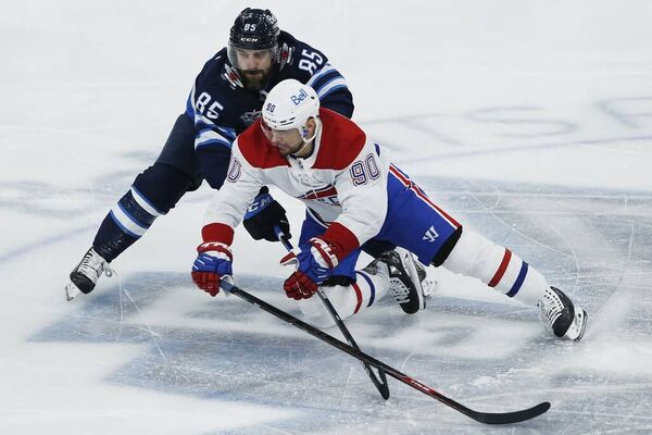 Winnipeg Jets' Mathieu Perreault (85) and Montreal Canadiens' Tomas Tatar (90) go for the puck during first period NHL action in Winnipeg on Thursday, February 25, 2021. 