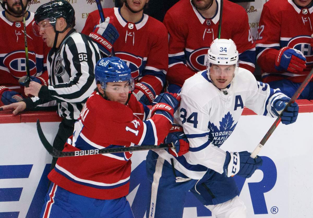 Montreal Canadiens' Nick Suzuki fends off Toronto Maple Leafs' Auston Matthews during second period NHL hockey action in Montreal on Wednesday, February 10, 2021.