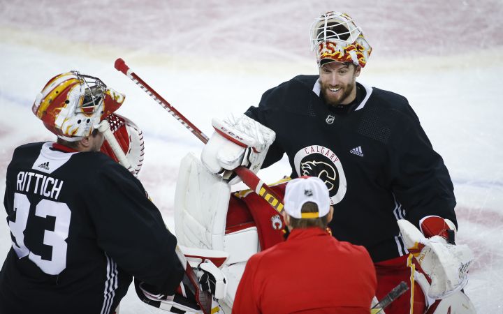 Calgary Flames goalie Jacob Markstrom, centre, covers the puck as