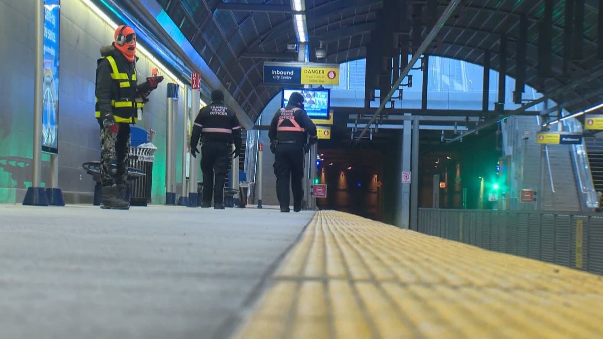Calgary Transit peace officers walk along the Westbrook LRT station, on Feb. 9, 2021.