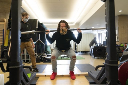 Physical therapist Eric Ross, left, watches as Joe DiMeo lifts weights, Monday, Jan. 25, 2021 at NYU Langone Health in New York.