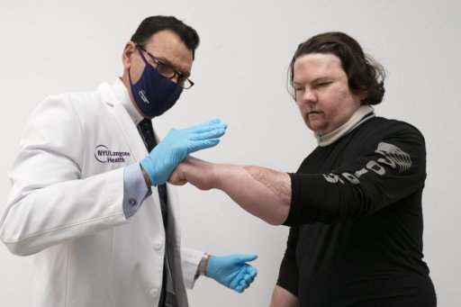 Dr. Eduardo Rodriguez has Joe DiMeo demonstrate the flexibility and strength in his hands, Monday, Jan. 25, 2021 at NYU Langone Health in New York, six months after an extremely rare double hand and face transplant.