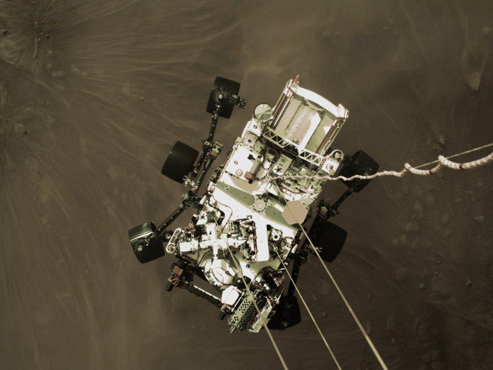 Photo provided by NASA shows the Perseverance rover lowered towards the surface of Mars during its powered descent. (NASA via AP).