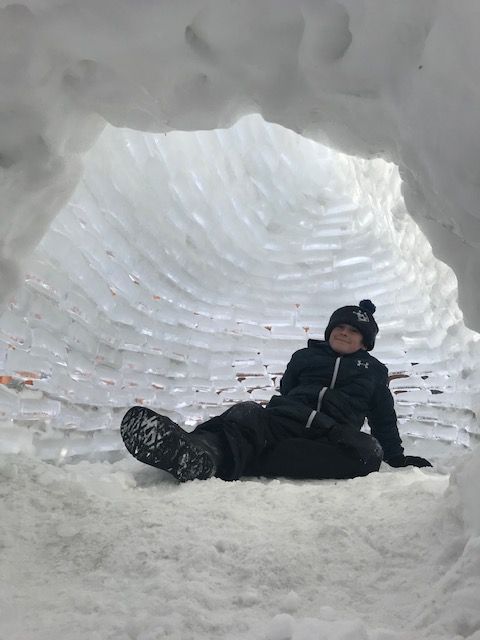 Sebastian McCarthy enjoys his handy work after building a pair of igloos in his Lloydminster, Alta., backyard.