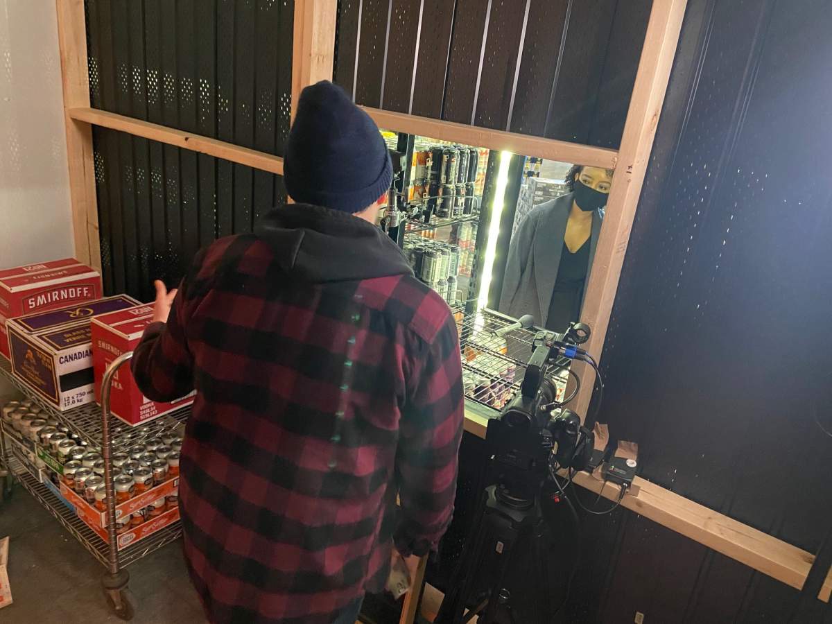 Image of actor behind cooler at Edmonton liquor store.