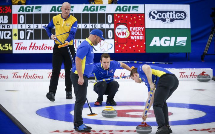 Team Alberta skip Brendan Bottcher, centre, directs his teammates as Team Wild Card Two skip Kevin Koe, left, looks on during the Brier curling final in Calgary, Alta., Sunday, March 14, 2021. 