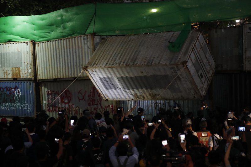 Protesters pull down a shipping container used as a barricade in front of the Grand Palace Saturday, March 20, 2021, in Bangkok, Thailand. Thailand's student-led pro-democracy movement is holding a rally in the Thai capital, seeking to press demands that include freedom for their leaders, who are being held without bail on charges of defaming the monarchy. 