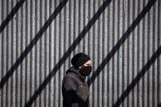 A pedestrian wears a face mask to curb the spread of COVID-19, in Vancouver, on Tuesday, February 16, 2021.