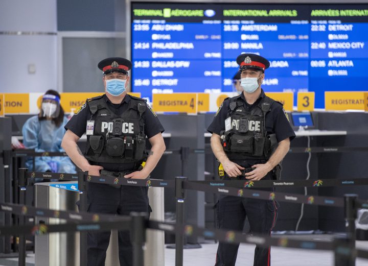 Police and workers wait for arrivals at the COVID-19 testing centre in Terminal 3 at Pearson Airport in Toronto on Wednesday, February 3, 2021.