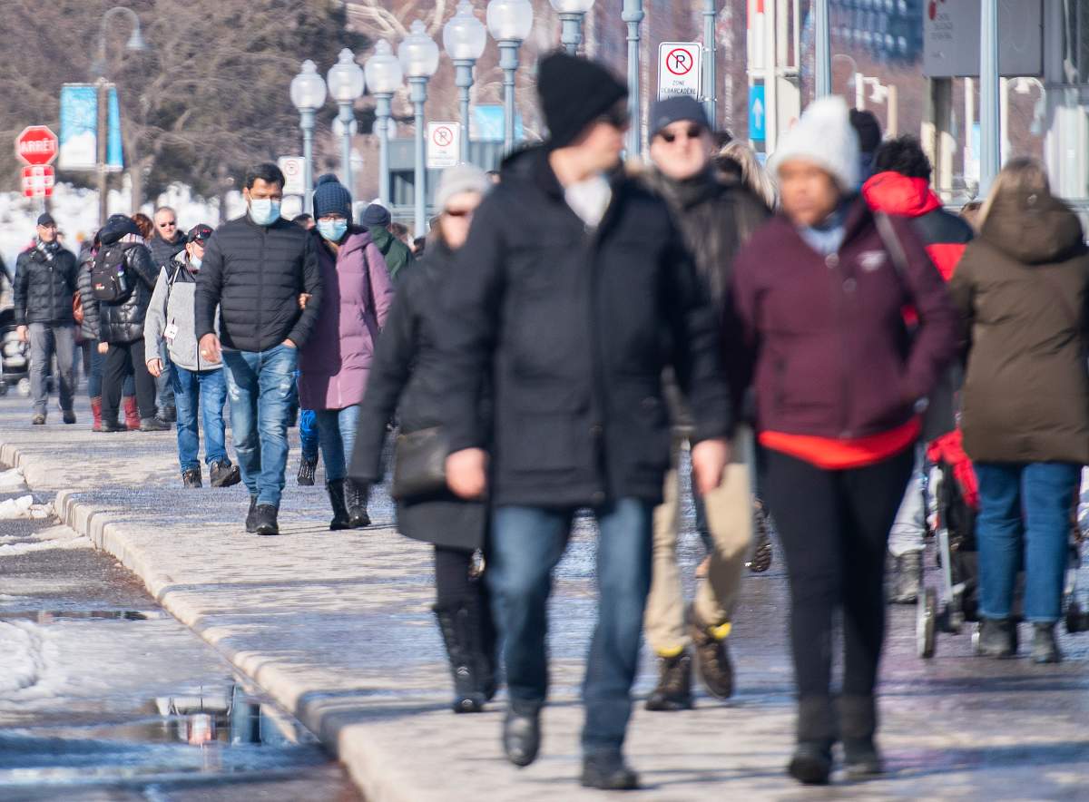 People wear face masks as they walk in the Old Port in Montreal, Sunday, Feb. 28, 2021, as the COVID-19 pandemic continues in Canada and around the world.