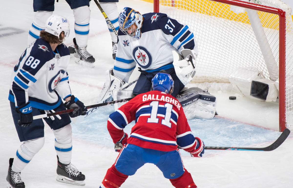 Montreal Canadiens’ Brendan Gallagher (11) scores against Winnipeg Jets goaltender Connor Hellebuyck as Jets’ Nathan Beaulieu (88) defends during second period NHL hockey action in Montreal, Saturday, March 6, 2021.