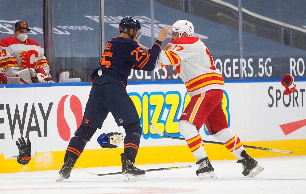 Edmonton Oilers' Darnell Nurse (25) and Calgary Flames' Milan Lucic (17) fight during first period NHL action in Edmonton on Saturday, March 6, 2021.THE CANADIAN PRESS/Jason Franson.