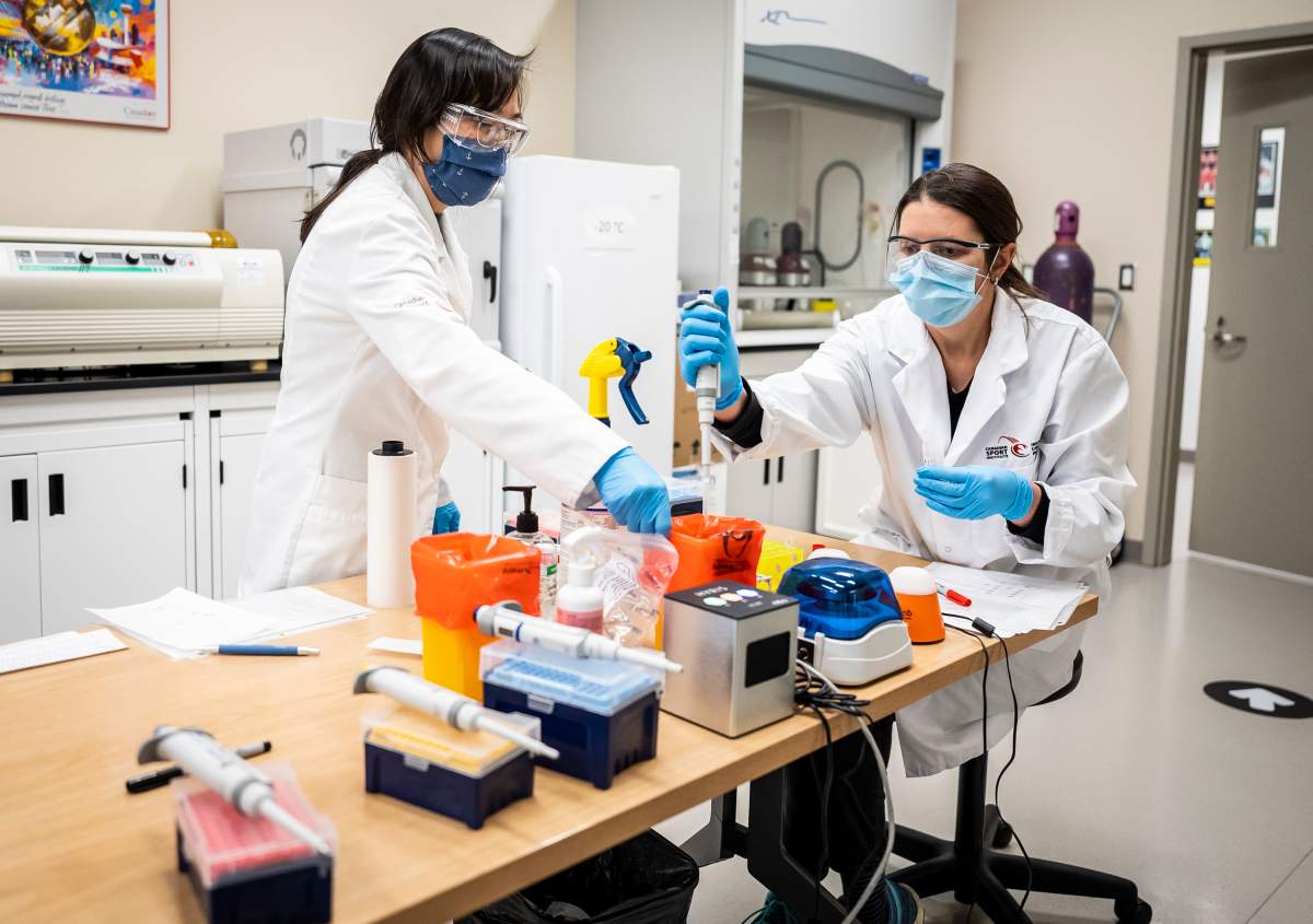Lab techs Mandy Chan and Maura Hooper work with the first swab samples to be tested for COVID-19 at the Canadian Sport Institute Calgary biochemistry lab in Calgary on January 15, 2020.