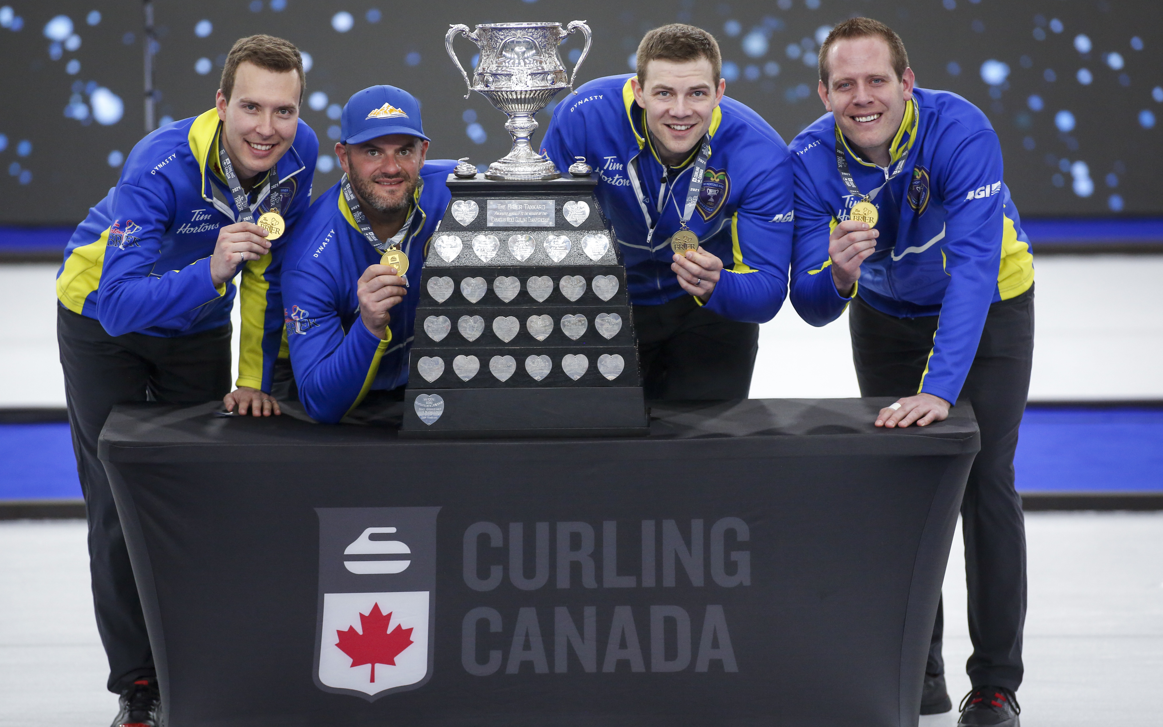 Team Alberta, vasemmalta oikealle, skip Brendan Bottcher, kolmas Darren Moulding, toinen Brad Thiessen, johtaa Karrick Martin juhlia kukistamalla Team villi kortti kaksi voittaa Brier curling final Calgary, Alta., Sunnuntai 14. Maaliskuuta 2021.