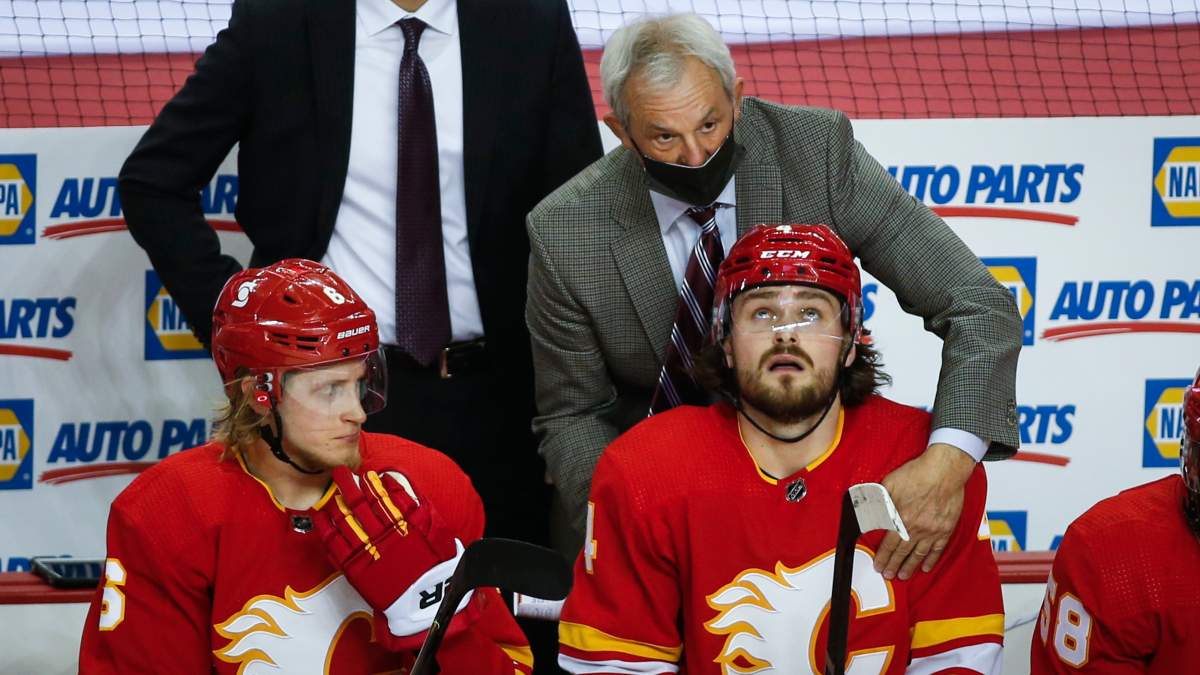 Calgary Flames’ head coach Darryl Sutter, centre, speaks with Rasmus Andersson, right, as Juuso Valimaki looks on during second-period NHL hockey action against the Edmonton Oilers in Calgary on Monday, March 15, 2021.