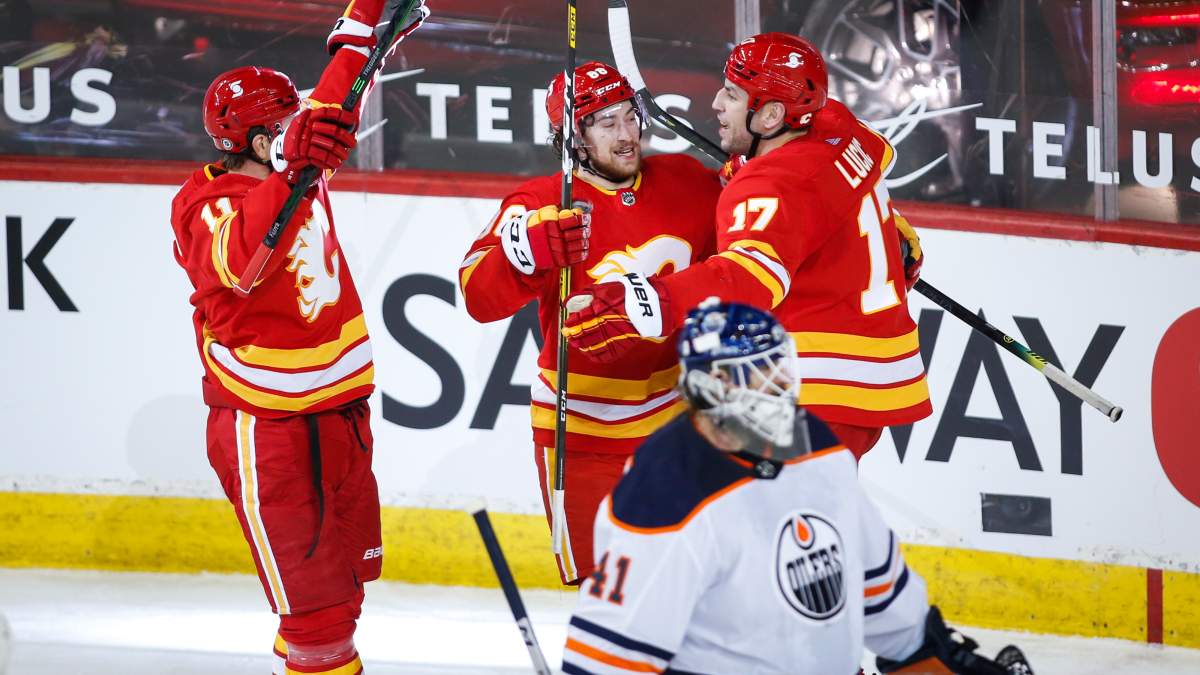 Edmonton Oilers goalie Mike Smith, centre, looks away as Calgary Flames’ Andrew Mangiapane, left, celebrates his goal with Milan Lucic during second-period NHL hockey action in Calgary on Monday, March 15, 2021.