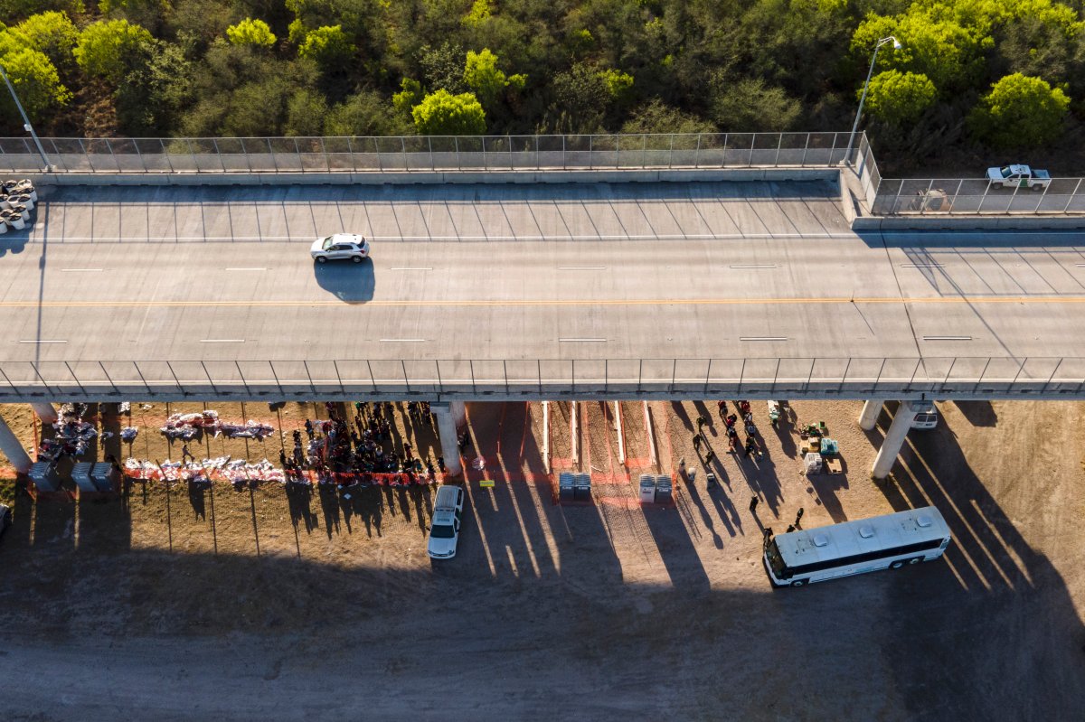 In this photo taken by a drone, migrants are seen in custody at a U.S. Customs and Border Protection processing area under the Anzalduas International Bridge, Thursday, March 18, 2021, in Mission, Texas.
