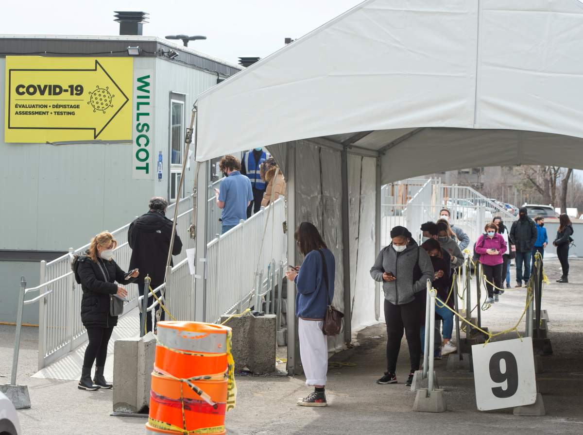 People line up at a COVID-19 testing clinic Wednesday, March 24, 2021 in Montreal. 
