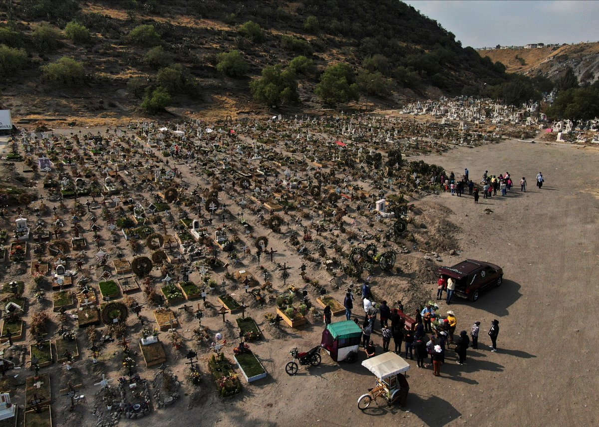 FILE - In this March 17, 2021 file photo, family members attend the burial service of a relative who died from COVID-19, in the Chalco cemetery on the outskirts of Mexico City, amid the new coronavirus pandemic.