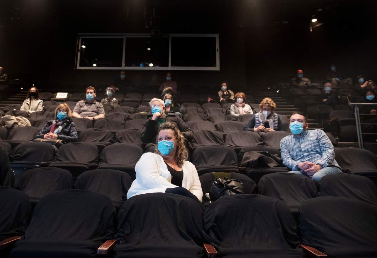 People wear face masks as they wait for the start of a performance of MOB at the Centaur Theatre in Montreal, Sunday, March 28, 2021, as the COVID-19 pandemic continues in Canada and around the world. Certain health and safety measures have been eased in the province of Quebec allowing theatres, churches and gyms to have up to 250 people on their premises. 