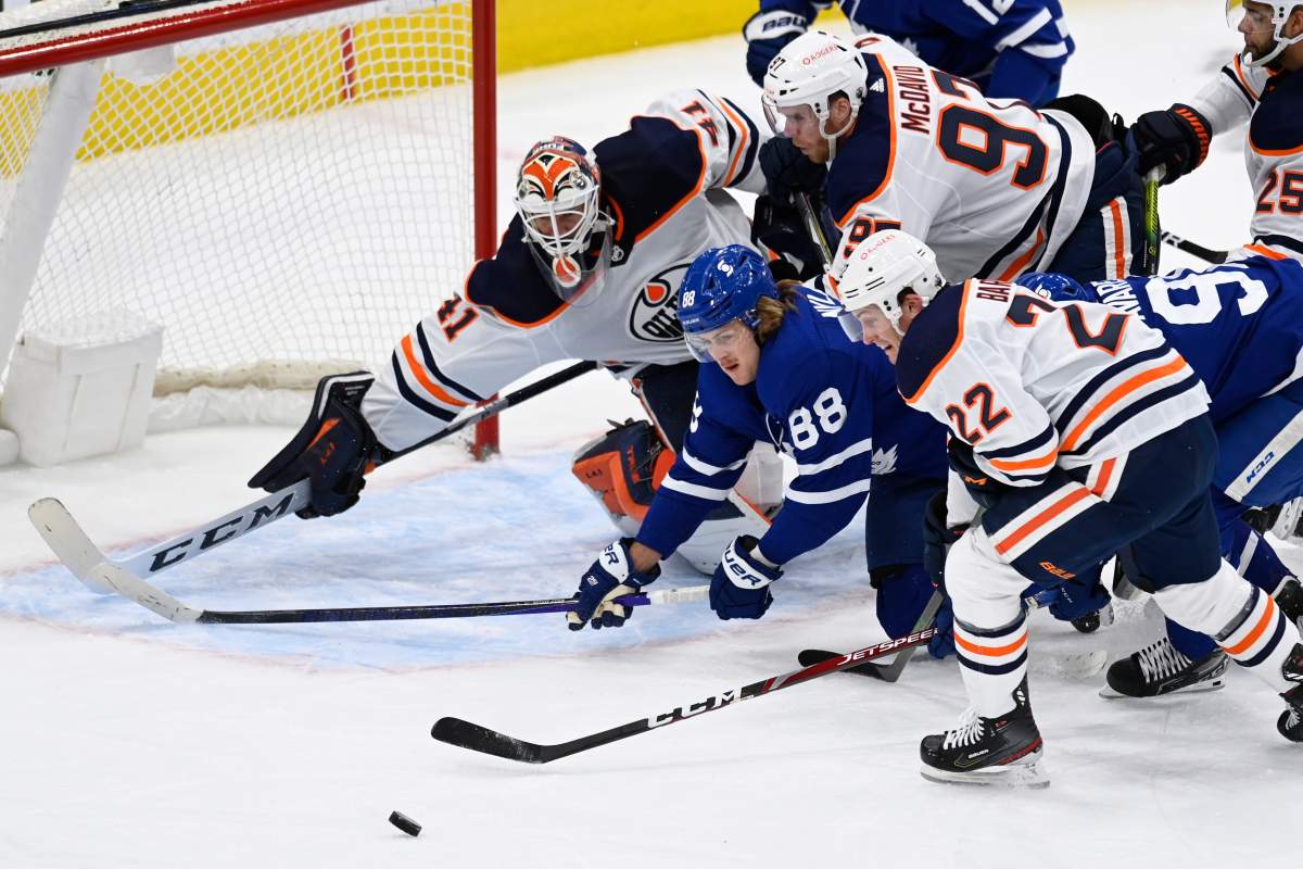 Edmonton Oilers goaltender Mike Smith (41) covers the net during scramble in front with Toronto Maple Leafs centre William Nylander (88) and Oilers defenceman Tyson Barrie (22) trying to get to the puck during first period NHL hockey action in Toronto on Monday March 29, 2021.