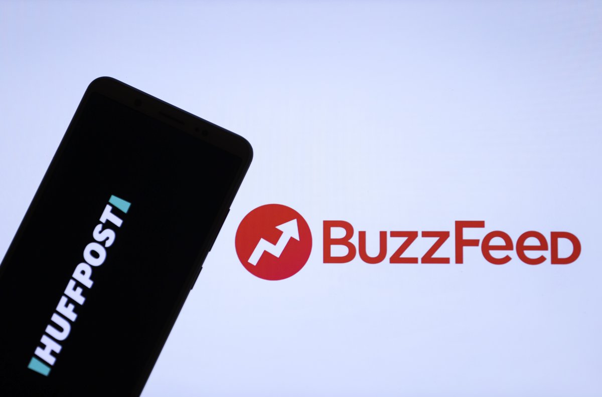 In this photo illustration, a mobile phone screen displays logo of the HuffPost in front of a computer screen displaying the logo of BuzzFeed in Ankara, Turkey on Dec. 1, 2020.