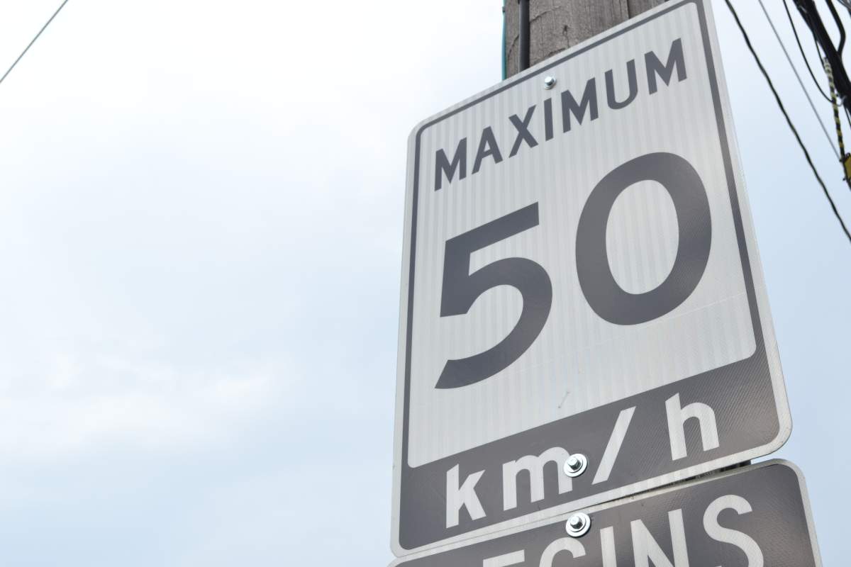 A speed limit sign states the maximum speed is 50 km/hr in that area.