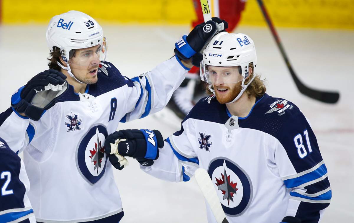 The Winnipeg Jets’ Mark Scheifele, left, celebrates his goal with teammate Kyle Connor during second-period NHL hockey action against the Calgary Flames in Calgary, Monday, March 29, 2021.