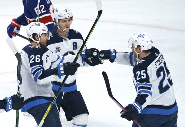The Winnipeg Jets' Paul Stastny, right, celebrates his goal against the Montreal Canadiens with teammates Blake Wheeler, left, and Mark Scheifele during the first period in Montreal on Thursday.