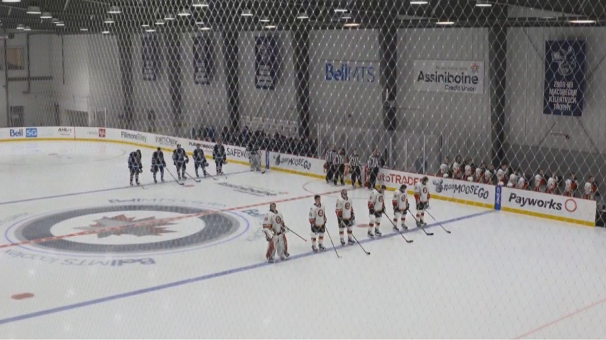 The Manitoba Moose and Stockton Heat stand for the national anthems in the first professional game at the Bell MTS Iceplex.
