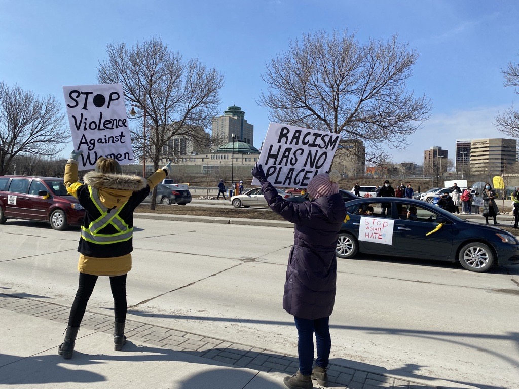 Cars lined the streets as people marched with signs during a vehicle rally against Asian hate. / MALIKA KARIM
