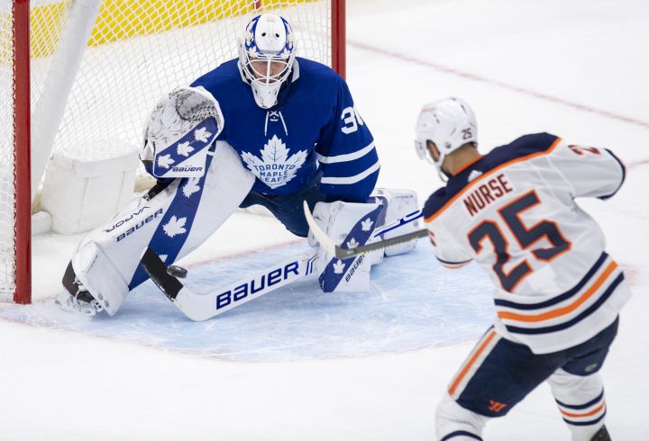 Edmonton Oilers defenceman Darnell Nurse (25) scores the game winning goal on Toronto Maple Leafs goaltender Michael Hutchinson (30) during overtime NHL action in Toronto on Monday March 29, 2021