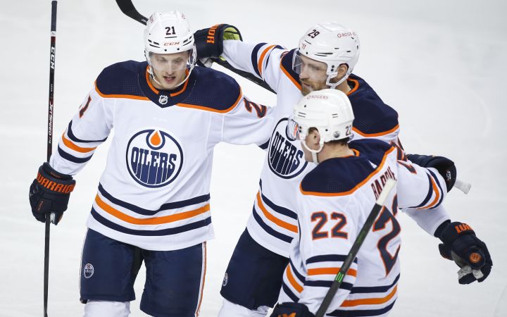 Edmonton Oilers’ Dominik Kahun, left, celebrates his goal with teammates Leon Draisaitl, centre, and Tyson Barrie during second period NHL hockey actionagainst the Calgary Flames in Calgary, Wednesday, March 17, 2021.