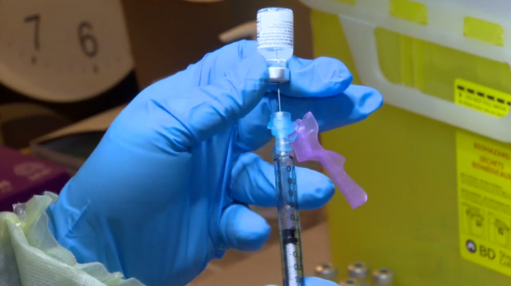 A health-care worker prepares a COVID-19 vaccine dose.