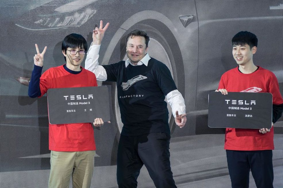 Tesla CEO Elon Musk poses with Tesla China-made Model 3 vehicle owners during a ceremony in Shanghai, east China, Jan. 7, 2020. 