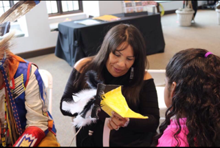 Rosa John, co-founder of Kehewin Native Dance Theatre, talks with a local youth at the Heard museum, during a youth mask workshop located in Phoenix, Ariz., in March 2020. 