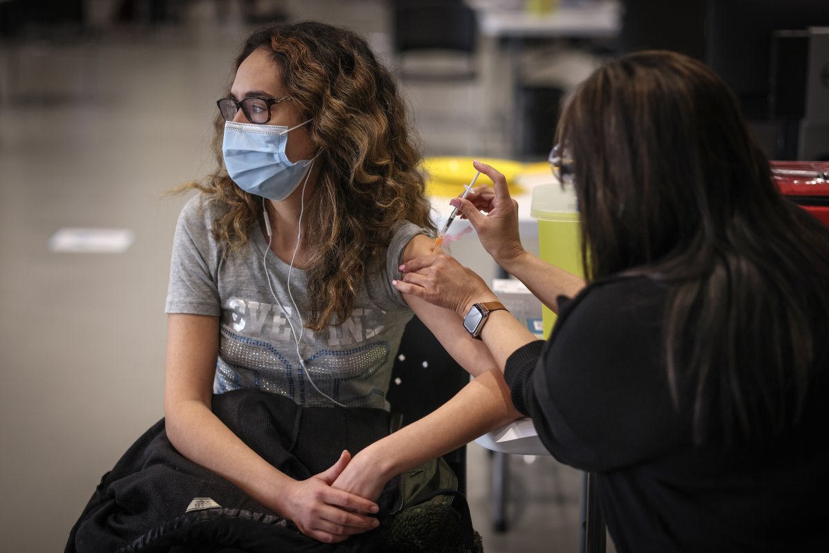 Nicole Fuerderer, 23, receives a COVID-19 vaccine from Nashria Valani, RN, at the Telus Convention Centre in Calgary, Alta, on April 19, 2021. 