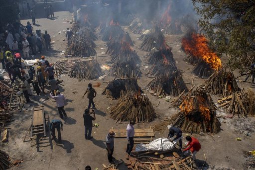 In this April 24, 2021, file photo, multiple funeral pyres of victims of COVID-19 burn at a ground that has been converted into a crematorium for mass cremation in New Delhi, India.