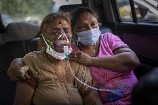In this April 24, 2021, file photo, a COVID-19 patient inside a car, receives oxygen provided by a Gurdwara, a Sikh house of worship, in New Delhi, India.