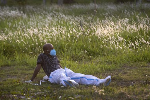 An exhausted municipal worker rests after bringing the body of a person who died of COVID-19 for burial in Gauhati, India, Sunday, April 25, 2021. As India suffers a bigger, more infectious second wave with a caseload of more than 300,000 new cases a day, the country’s healthcare workers are bearing the brunt of the disaster.