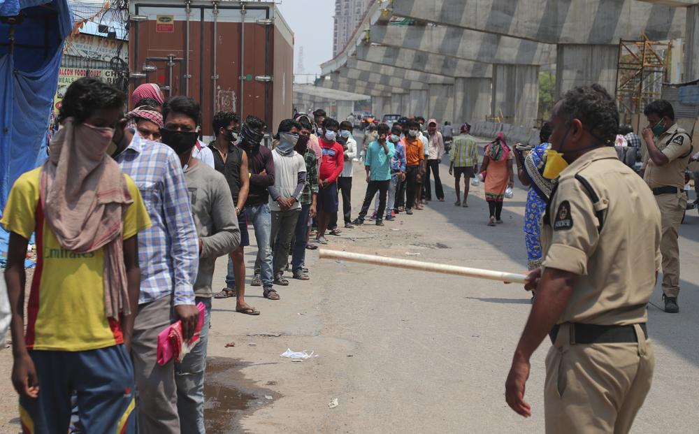 In this April 18, 2020, file photo, Indians stand in a queue to receive food distributed by volunteers during lockdown to prevent the spread of new coronavirus in Hyderabad, India.