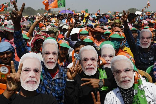In this March 7, 2021, file photo, Bharatiya Janata Party (BJP) supporters wear masks of Prime Minister Narendra Modi as they gather for a rally addressed by Modi ahead of West Bengal state elections in Kolkata, India.