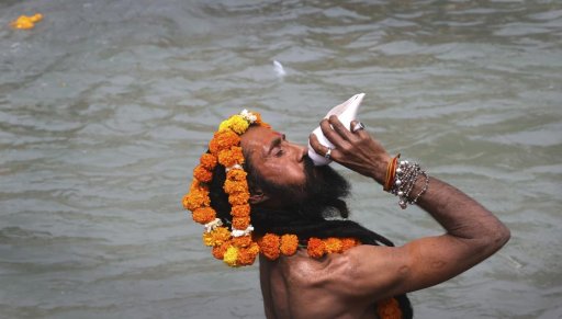 In this April 12, 2021, file photo, a Hindu holy man blows a Conch shell as devotees take holy dips in the Ganges River during Kumbh Mela, or pitcher festival, one of the most sacred pilgrimages in Hinduism, in Haridwar, northern state of Uttarakhand, India.