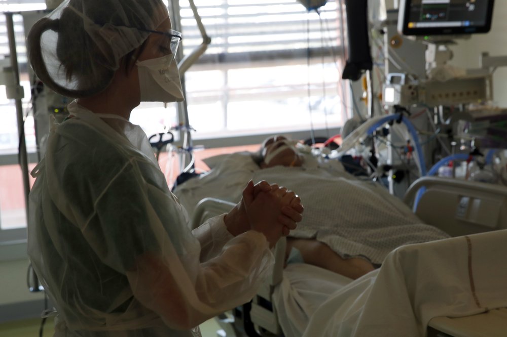 A medical worker tends to a patient affected with the COVID-19 in the Amiens Picardie hospital Tuesday, March 30, 2021 in Amiens, 160 km north of Paris.