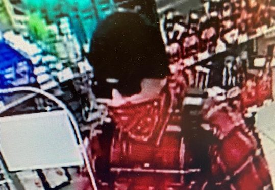The suspect in an April 5 armed robbery was last seen wearing a red and black plaid shirt. 