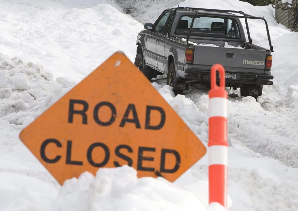 A road closed sign is placed at the bottom of a steep hill after several snow storms made some roads unuseable in North Vancouver Sunday, Dec. 28, 2008. 