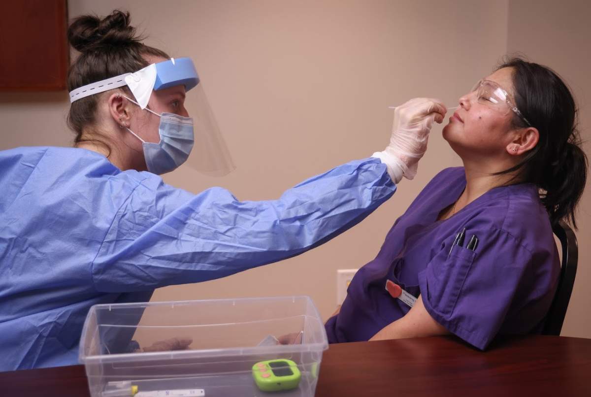 A health-care worker conducts a COVID-19 rapid test in Calgary on March 1, 2021.