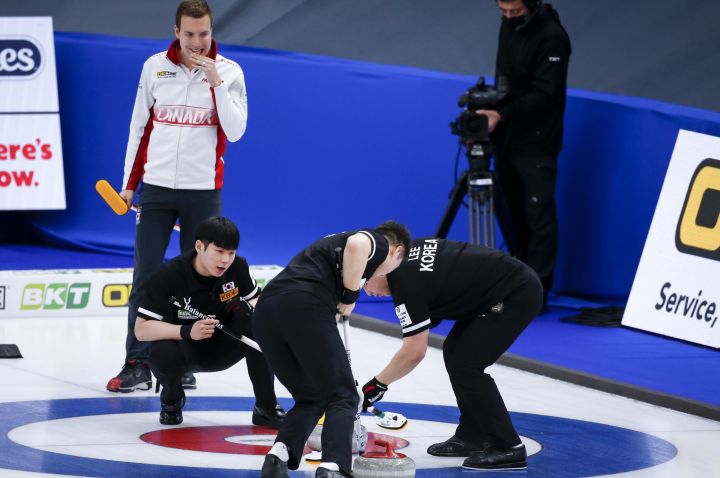 Team Canada skip Brendan Bottcher, left, looks on as South Korea skip Yeong Seok Jeong directs his teammates  at the Men's World Curling Championships in Calgary, Alta., Monday, April 5, 2021.