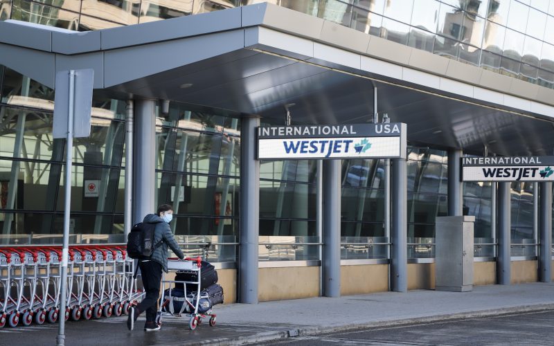 A lone traveler enters the Calgary Airport in Calgary, Alta., Monday, Feb. 22, 2021. 